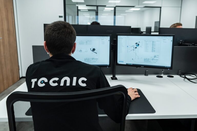 defense tech money - A person works on a computer in an office.