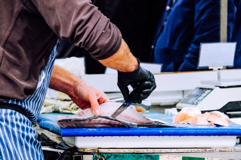 humanely killed fish - a man cutting up a fish on a cutting board