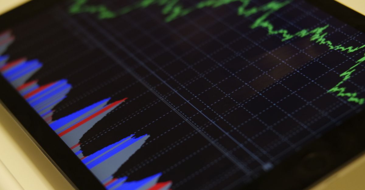 spacex stock volatility - Close-up of a tablet displaying stock market analysis with colorful graphs.