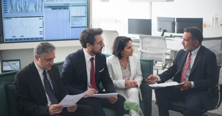 alts implementation - Group of business professionals discussing financial strategies in a modern office setting.