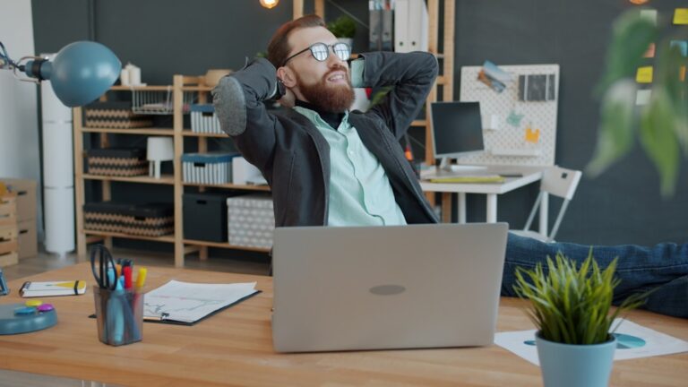 smartstream smart agents - Man relaxing at his office desk with laptop.