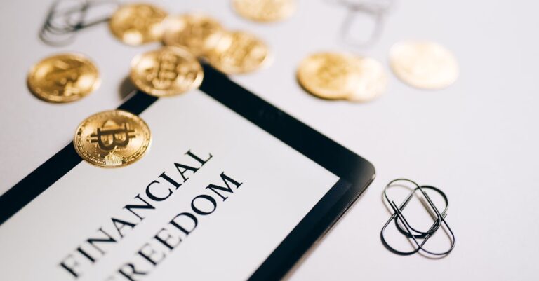 egyptian pos financing - Close-up of Bitcoin coins and an iPad displaying 'Financial Freedom,' symbolizing modern digital sav
