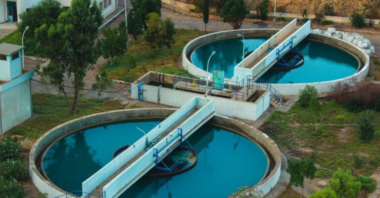 blue bonds finance - Drone shot of an advanced water purification plant surrounded by trees.