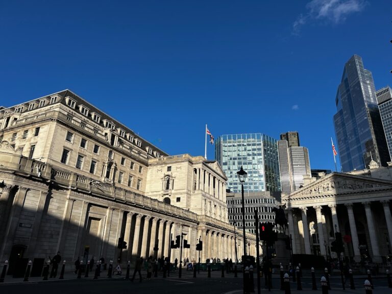 stablecoin ownership limits - Modern and historic buildings under a clear blue sky.