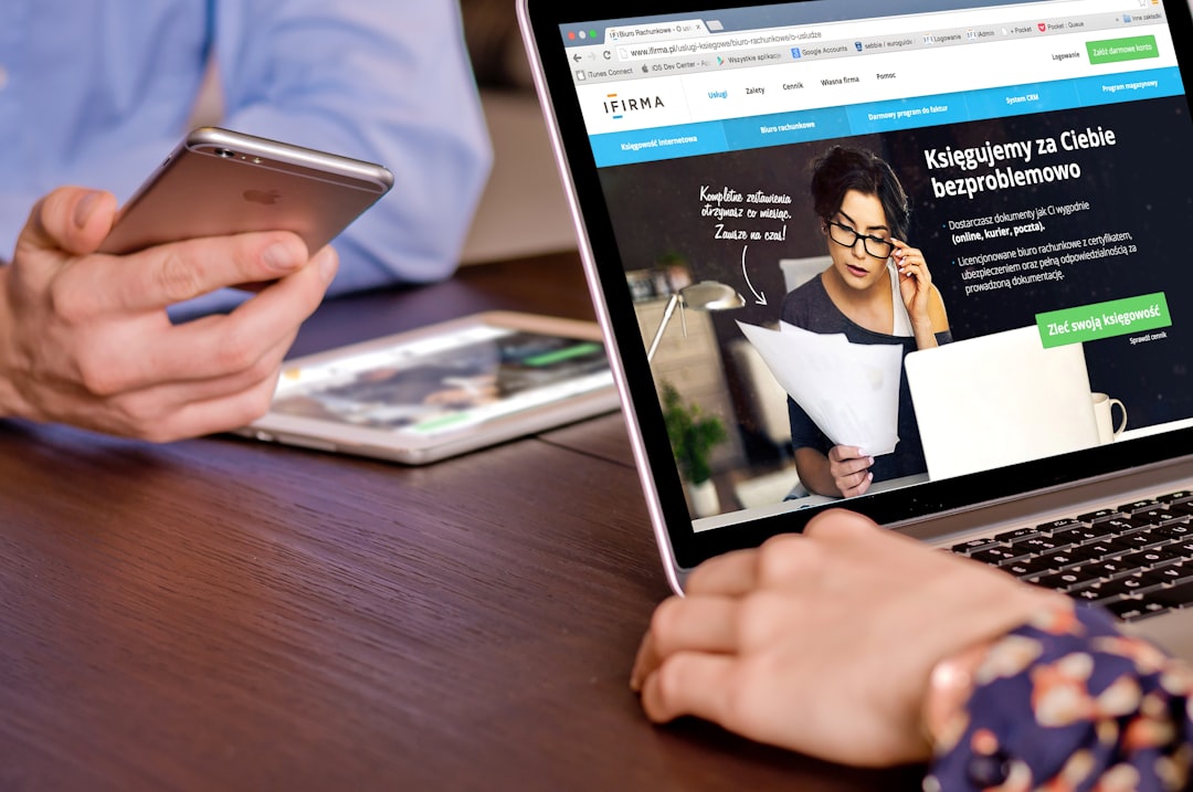cfpb webpage deletion - a person on a cell phone and a laptop on a table