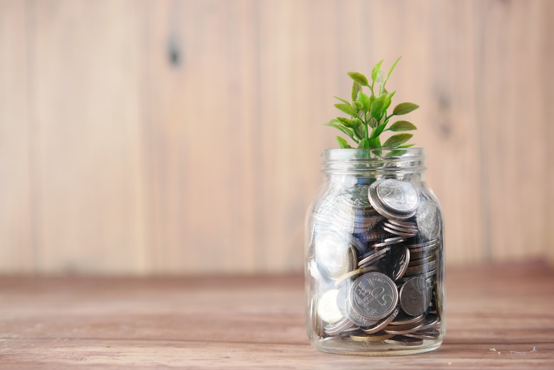 comcast stock performance - a glass jar filled with coins and a plant
