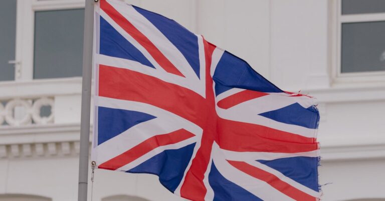 fca crypto etns - Close-up of the Union flag waving in front of a building in an urban area.