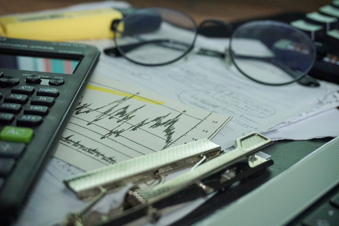 free cash flow portfolio - A desk with a calculator, papers, eyeglasses, and office supplies.