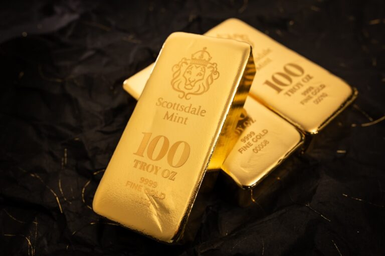 gold reserve asset - Several gold bars stacked on a dark surface