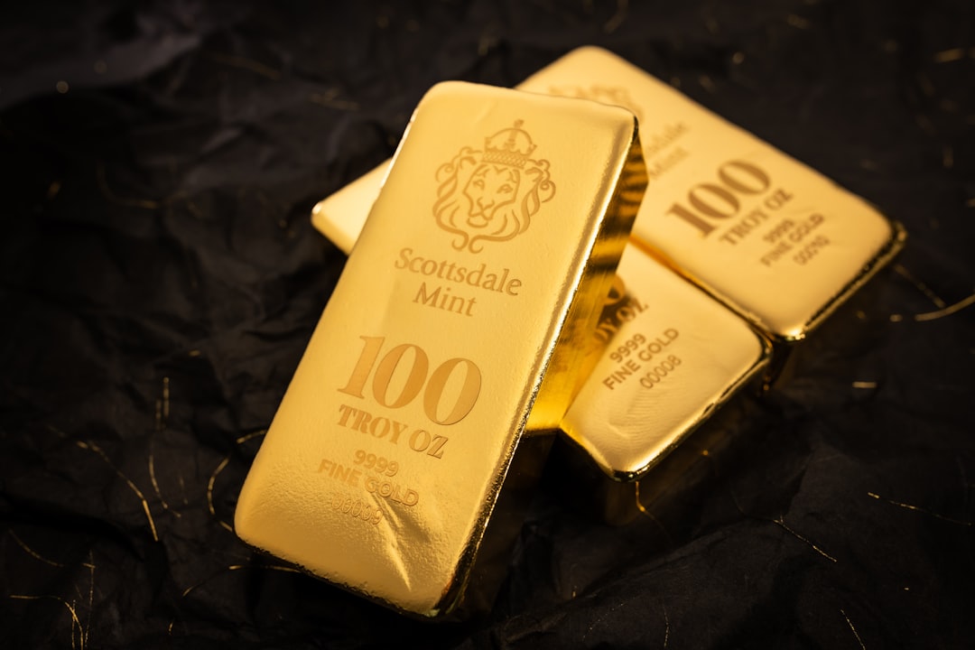 gold reserve asset - Several gold bars stacked on a dark surface