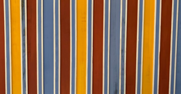 lloyds stripe smes - A colorful close-up of a striped painted wall with vertical blue, yellow, and red lines.