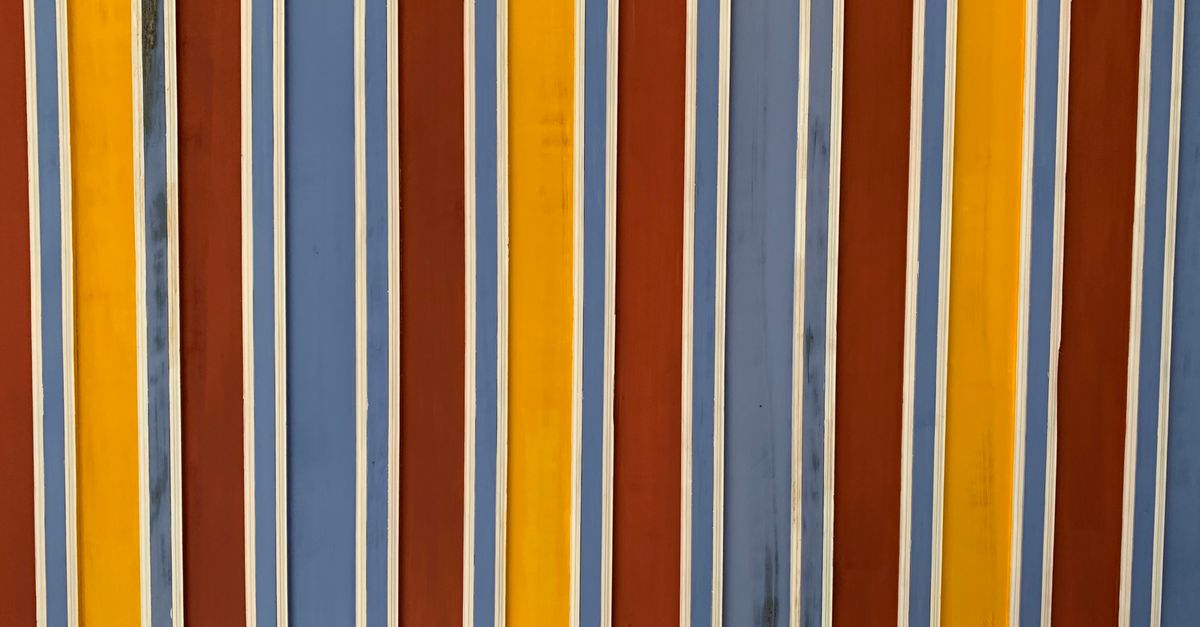 lloyds stripe smes - A colorful close-up of a striped painted wall with vertical blue, yellow, and red lines.