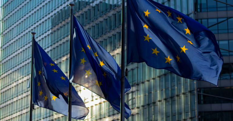 binance mica license - EU flags waving in front of the European Commission building in Brussels, Belgium.