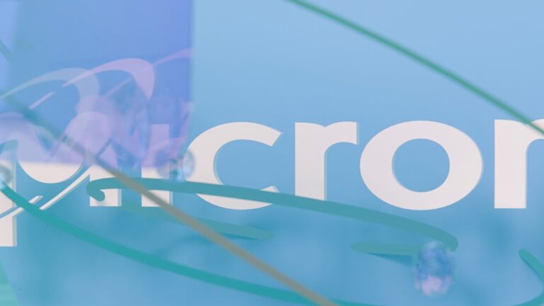 micron stock - Partial micron logo on light blue background with abstract swirls.