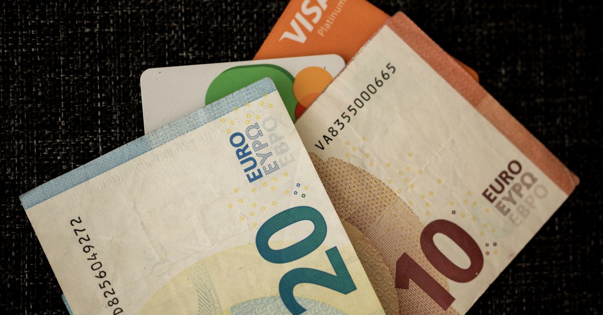 visa openai partnership - Close-up of euro banknotes and credit cards on a dark textured surface.