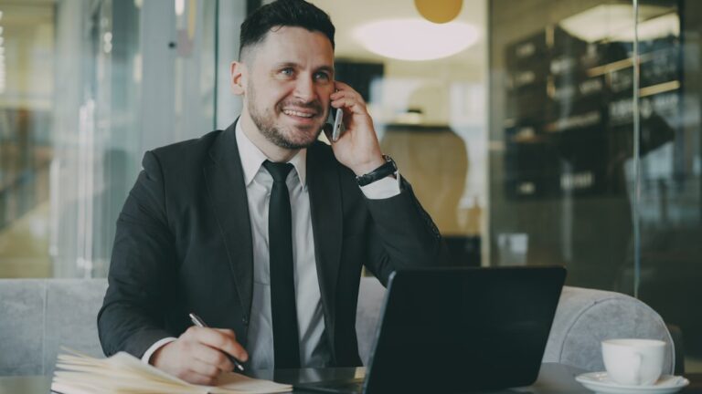 small business efficiency - Man in suit talking on phone at laptop