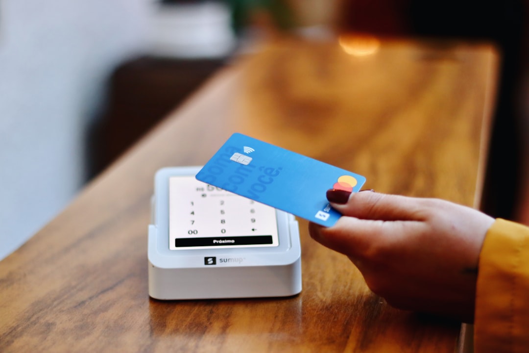 payment gateway - a person holding a credit card in front of a machine