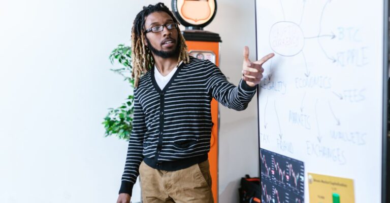 agentic AI finance - Man explaining cryptocurrency concepts on a whiteboard in a modern office setting.