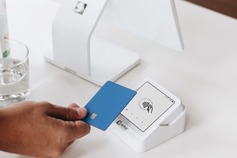merchant acquiring payments - A person holding a card in front of a computer
