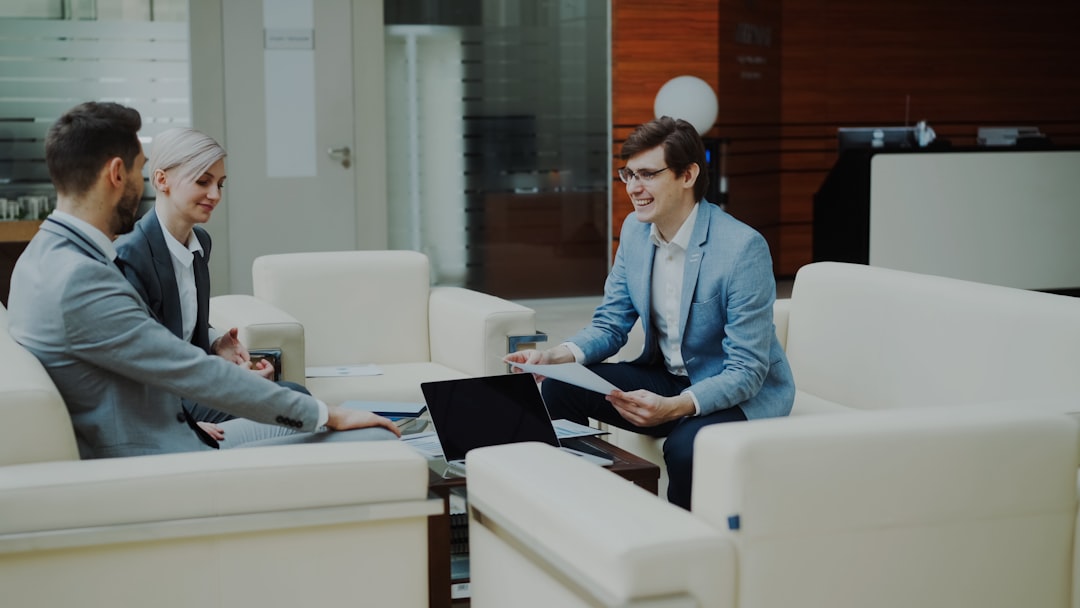 respond.io funding - Three business people in a modern office meeting.