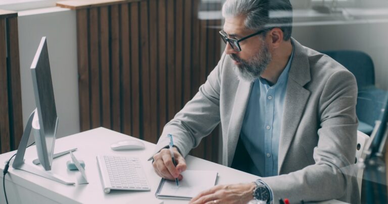 hourly workers financial planning - A man sitting at a desk writing on a piece of paper