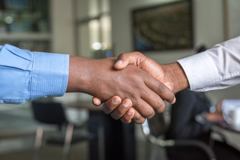 alphacore adds ria - two people shaking hands