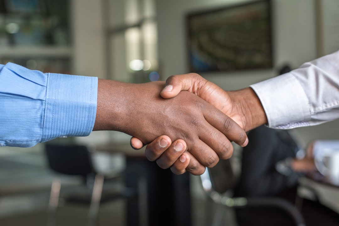 alphacore adds ria - two people shaking hands