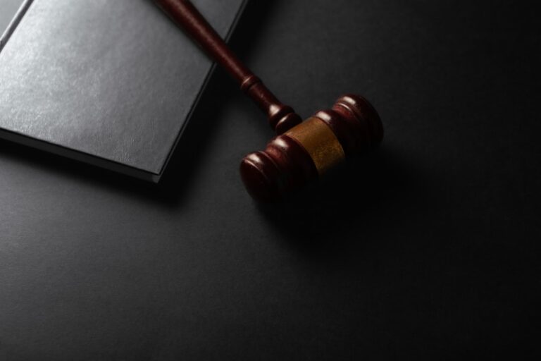 bank-fintech partnerships - Wooden gavel resting on a dark surface next to book