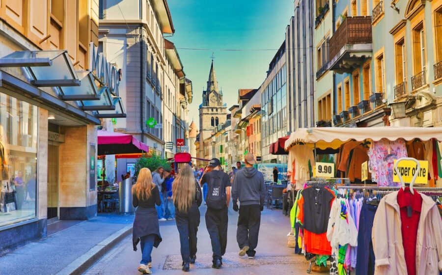 ai in banking - People walk down a sunny european street with shops.