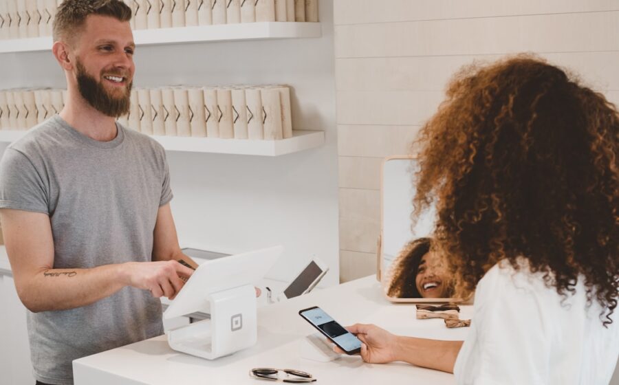 ai customer experience - man in grey crew-neck t-shirt smiling to woman on counter