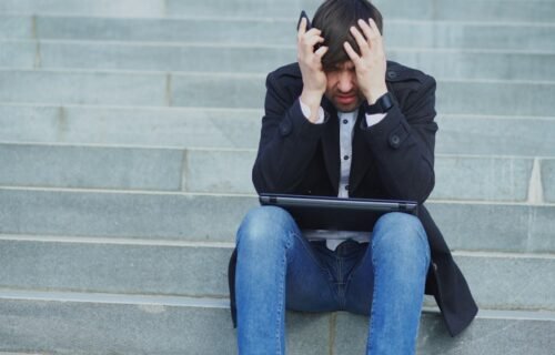 ai in banking - Man sitting on steps with head in hands