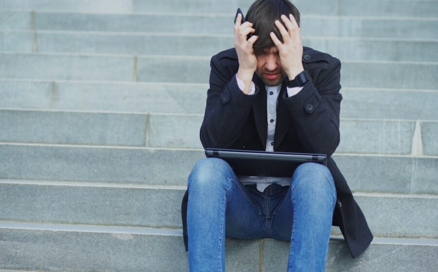 ai in banking - Man sitting on steps with head in hands