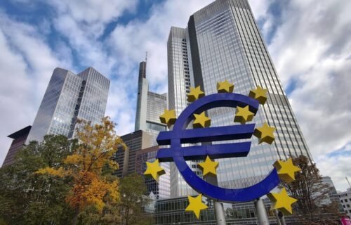 stablecoin growth - Iconic Euro sculpture with modern skyscrapers in Frankfurt, Germany showcasing the financial district.