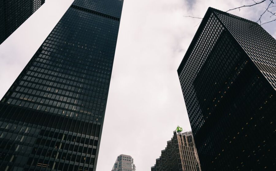 bank stock earnings - Low angle view of modern skyscrapers against a cloudy sky in a city.