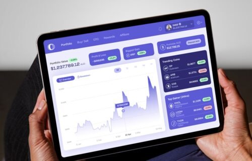 blockchain transfer agency - a person holding a tablet displaying a stock chart