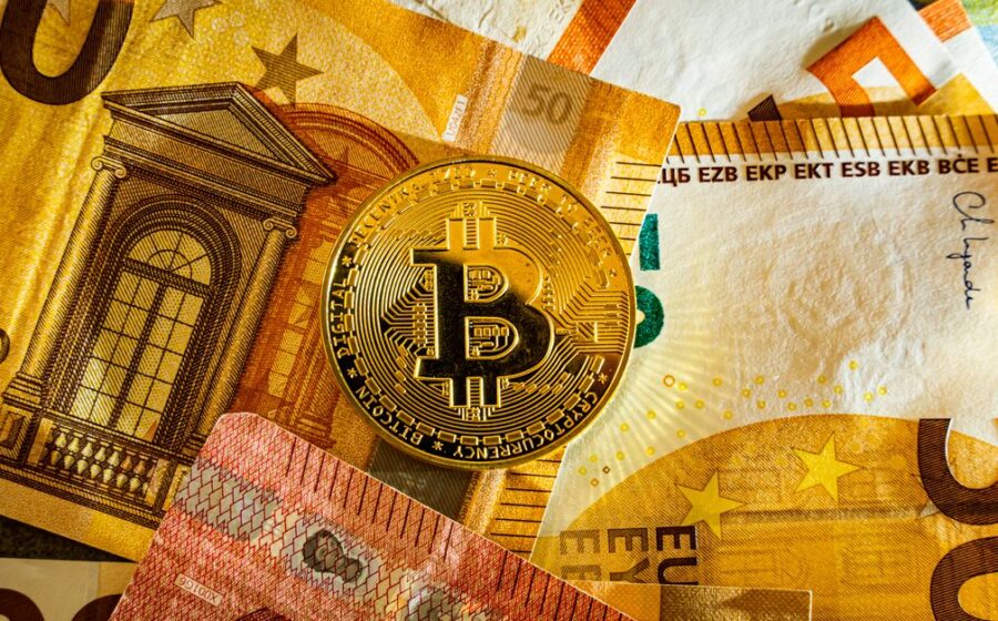 digital euro pilot - Golden Bitcoin coin placed on euro banknotes symbolizing digital currency and modern finance.