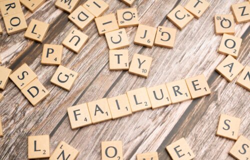 scrabble tiles spelling failure and love on a wooden surface