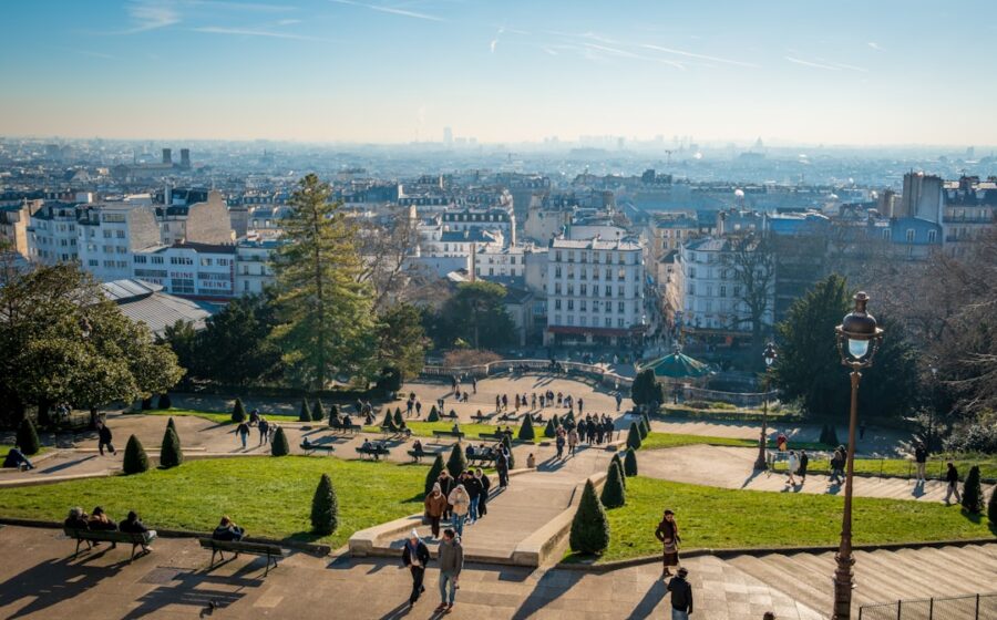 polymarket france ban - People walk down a hill overlooking the city.