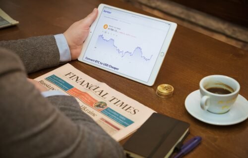 a person sitting at a table with a tablet and a cup of coffee