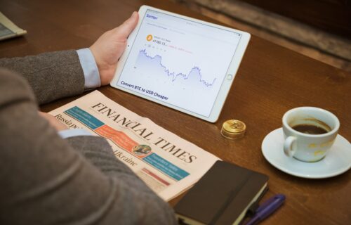 a person sitting at a table with a tablet and a cup of coffee