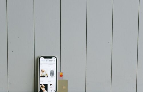 paypal stripe offer - A smartphone displaying an ecommerce site with a credit card, set on a wooden surface, depicting online