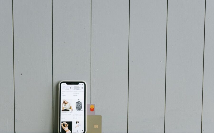 paypal stripe offer - A smartphone displaying an ecommerce site with a credit card, set on a wooden surface, depicting online