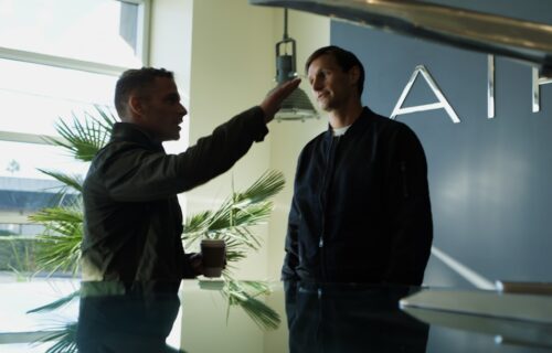 pixverse raises $439m - Two men talking near an airplane model.