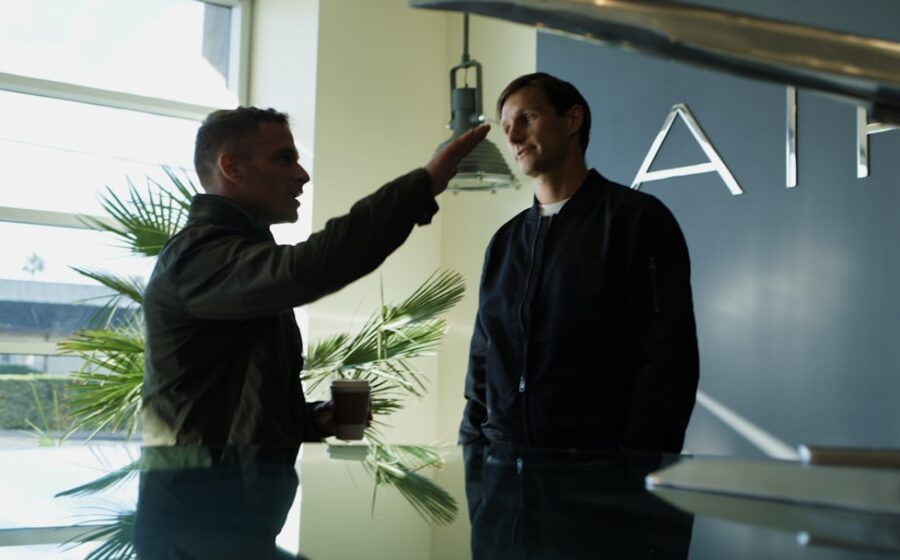pixverse raises $439m - Two men talking near an airplane model.