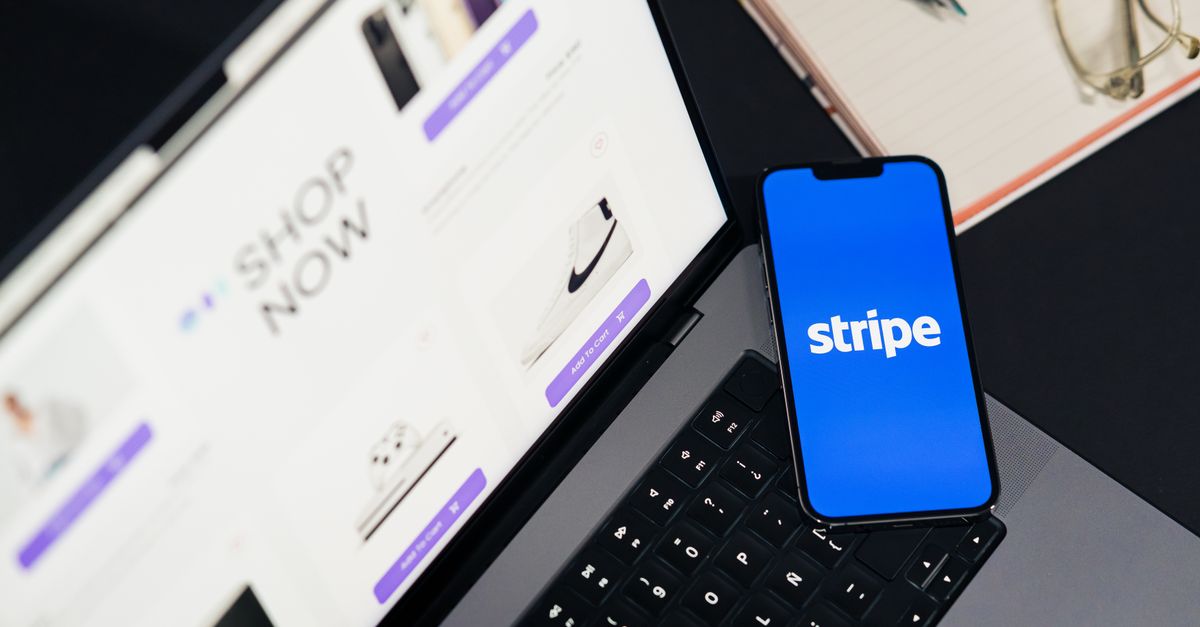 servicenow salesforce buys - Mobile phone displaying Stripe app on a laptop with an eCommerce site open, symbolizing online s