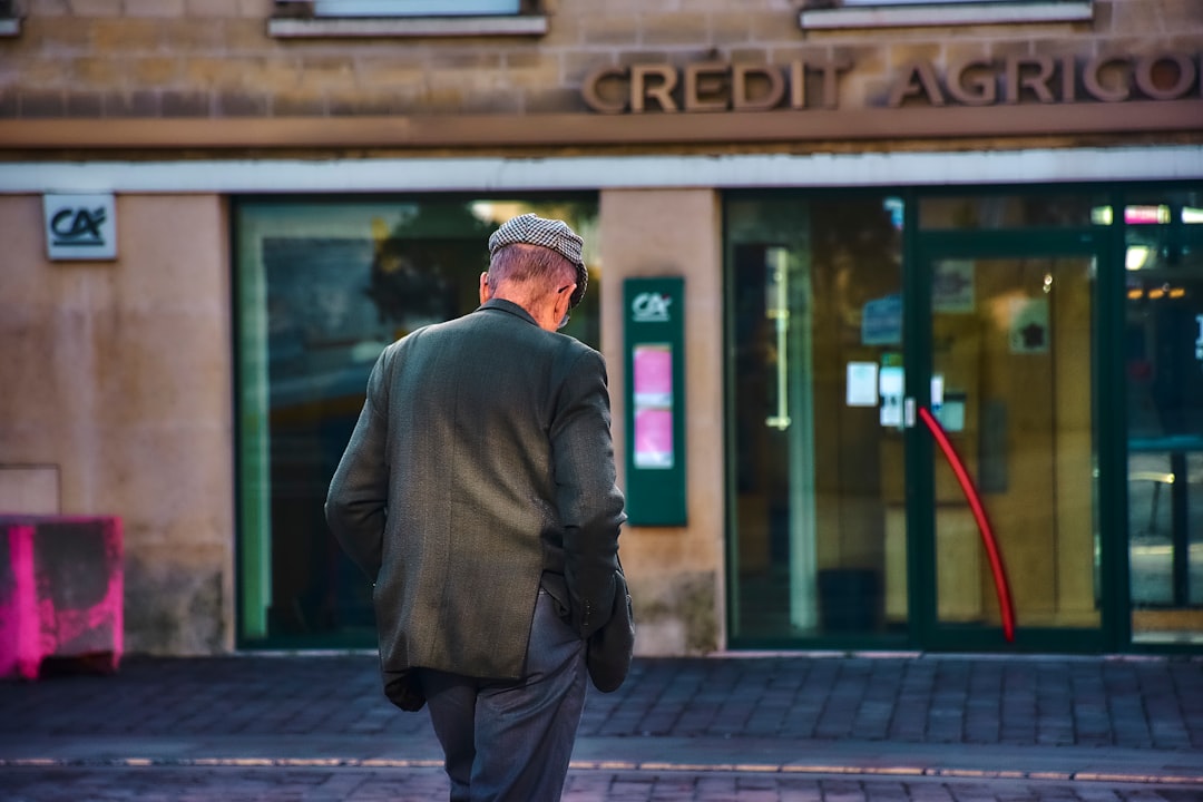 euro stablecoin launch - Man walks towards a crédit agricole bank entrance.