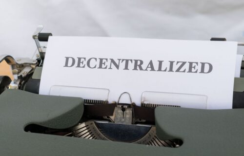 tokenisation in banking - Close-up of a vintage typewriter with paper showing the word 'Decentralized'.