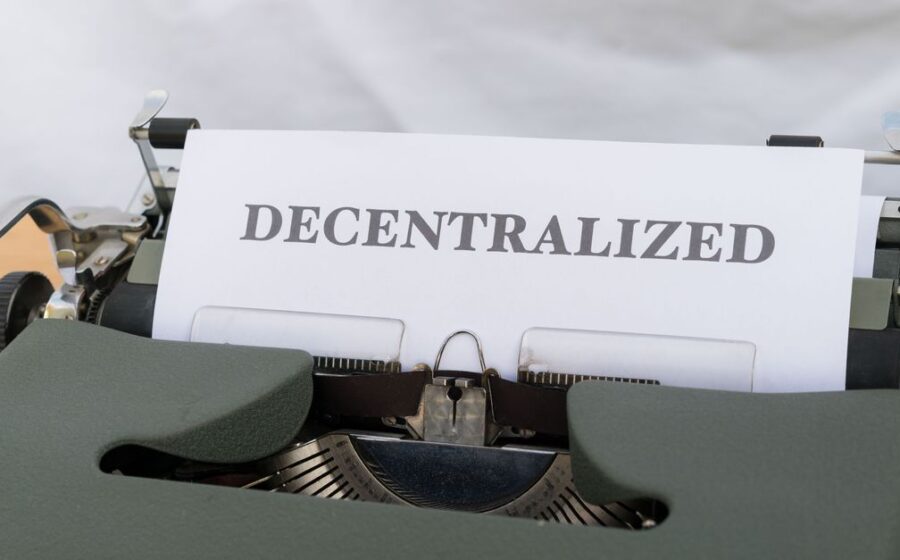 tokenisation in banking - Close-up of a vintage typewriter with paper showing the word 'Decentralized'.