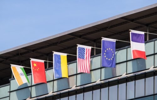 ai supremacy ban - Flags of various nations fly on building.