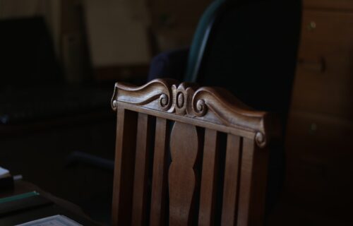 fed chair warsh - brown wooden armless chair inside room
